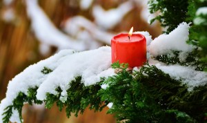 Brennende rote Kerze auf schneebedecktem Zweig | Foto: pixabay/congerdesign